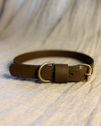 Ett brunt halsband med mässing detaljer