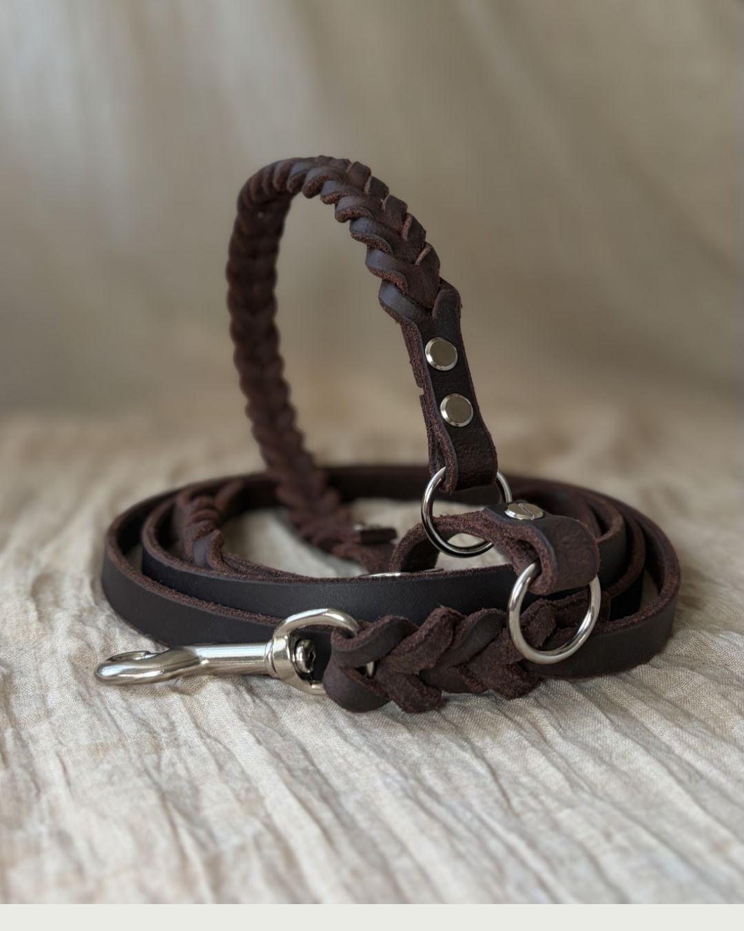 Flätat läderhalsband med ett läderkoppel.