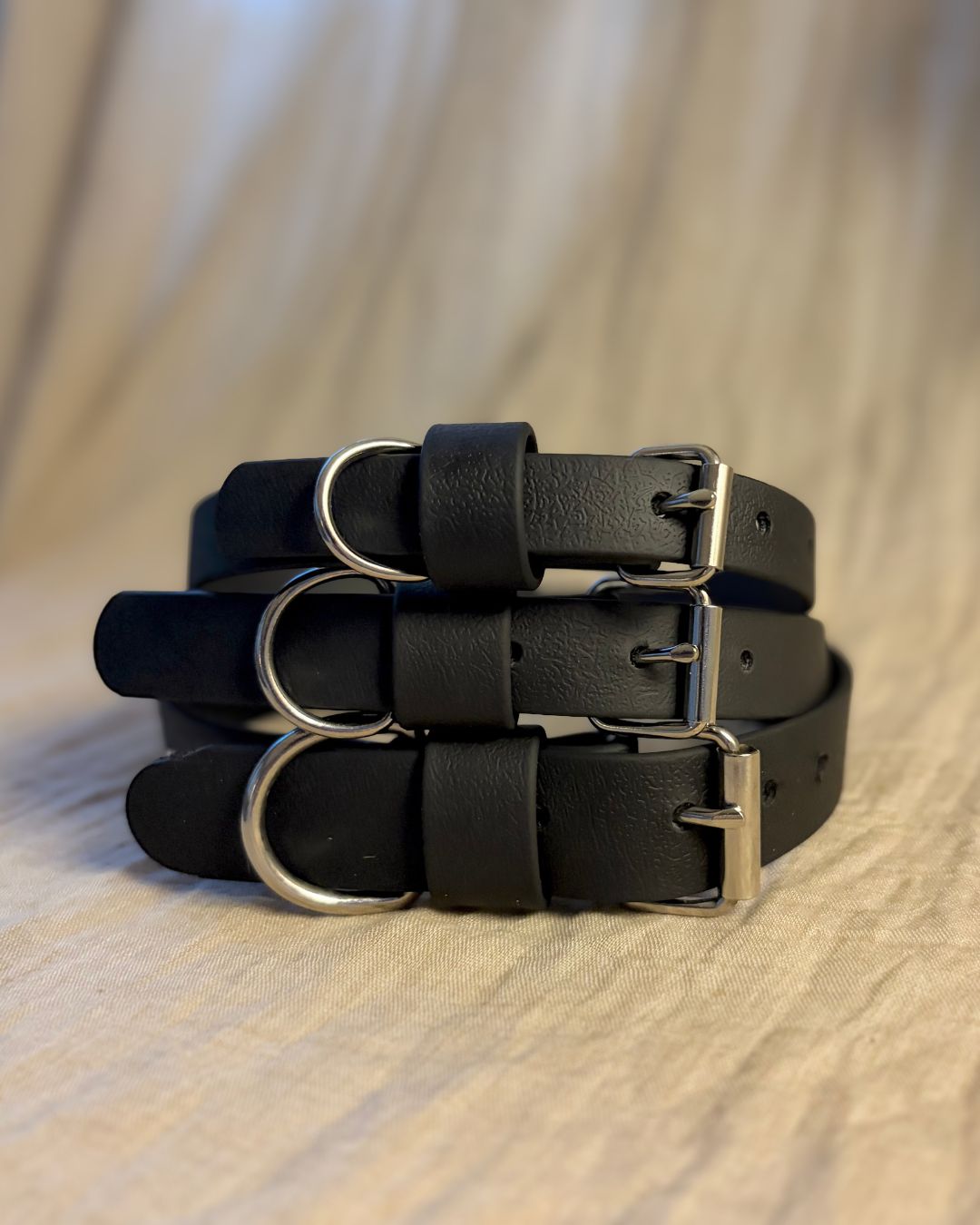 Tre svarta hundhalsband i olika storlekar.