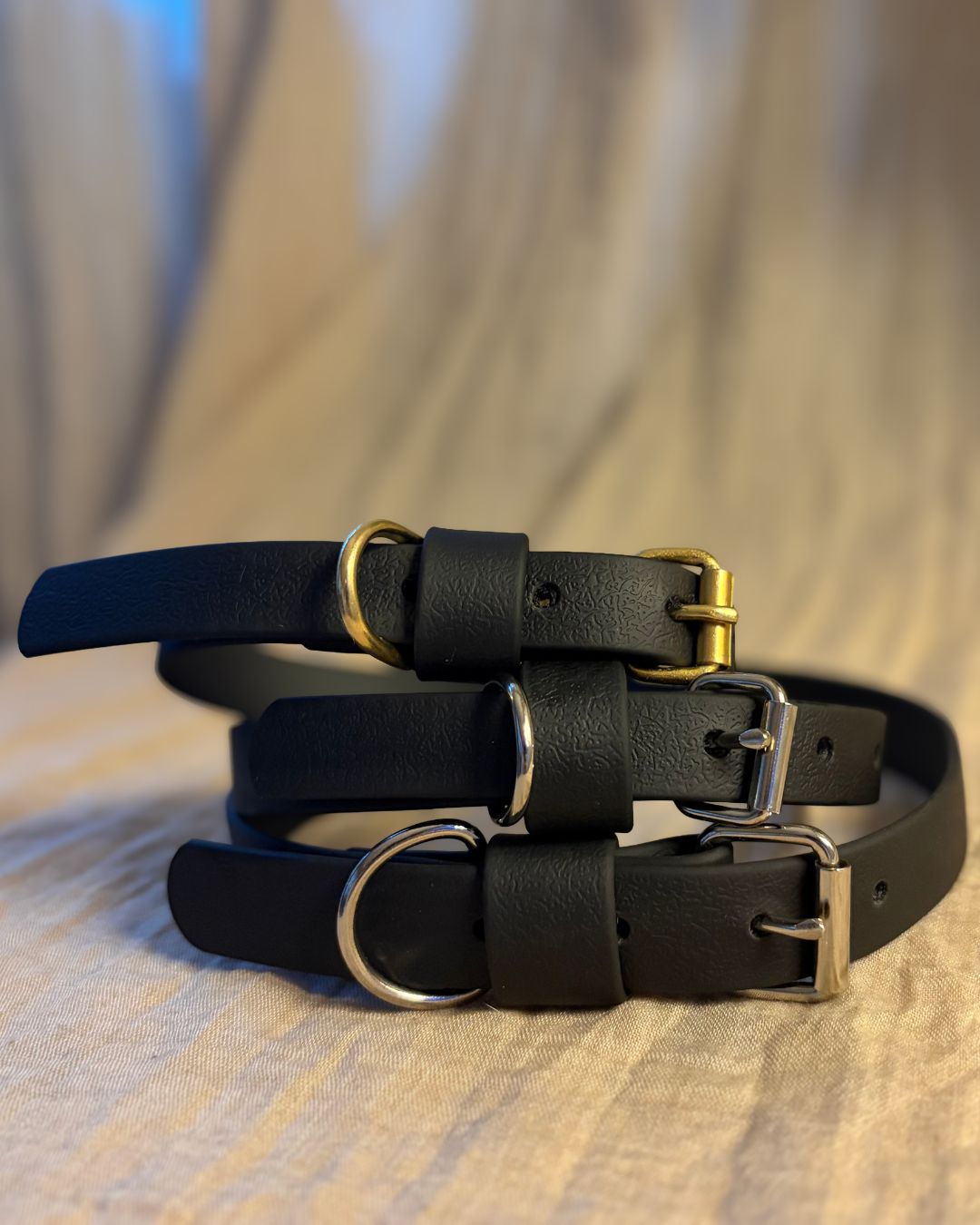 Tre svarta hundhalsband i olika storlekar och detaljer.